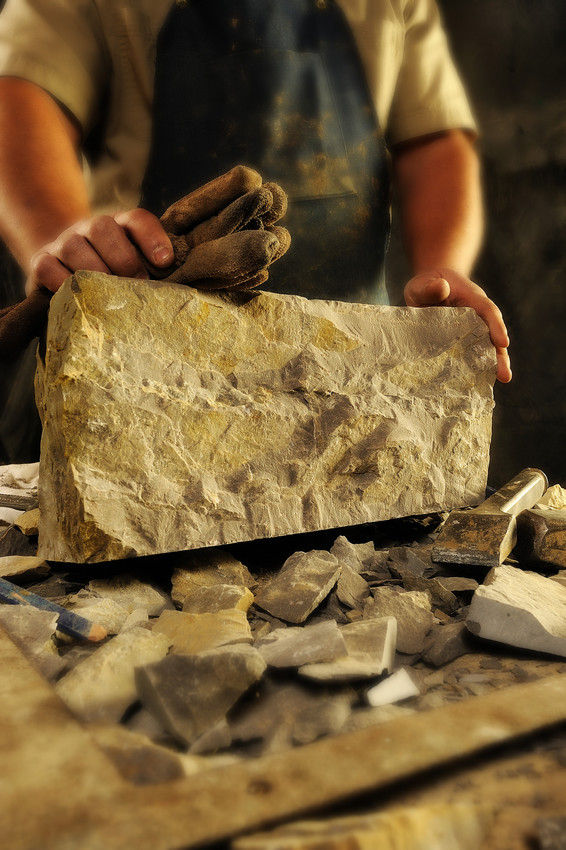 A mason carves a block of Hokie Stone